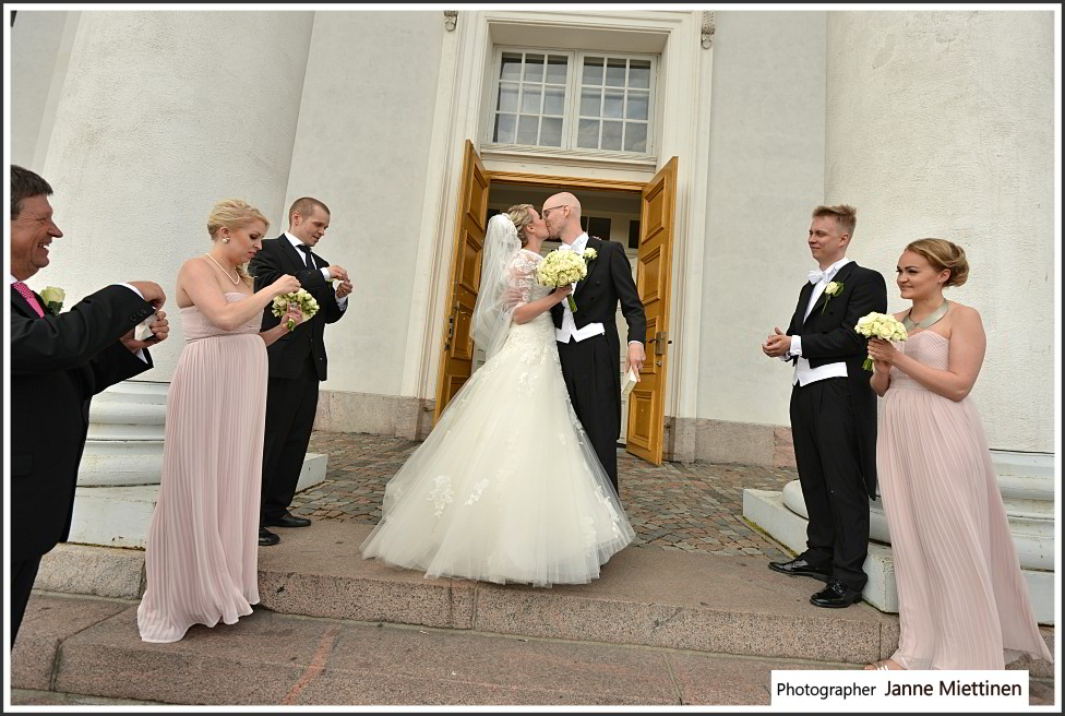 Hääpari suutelee kirkon portailla